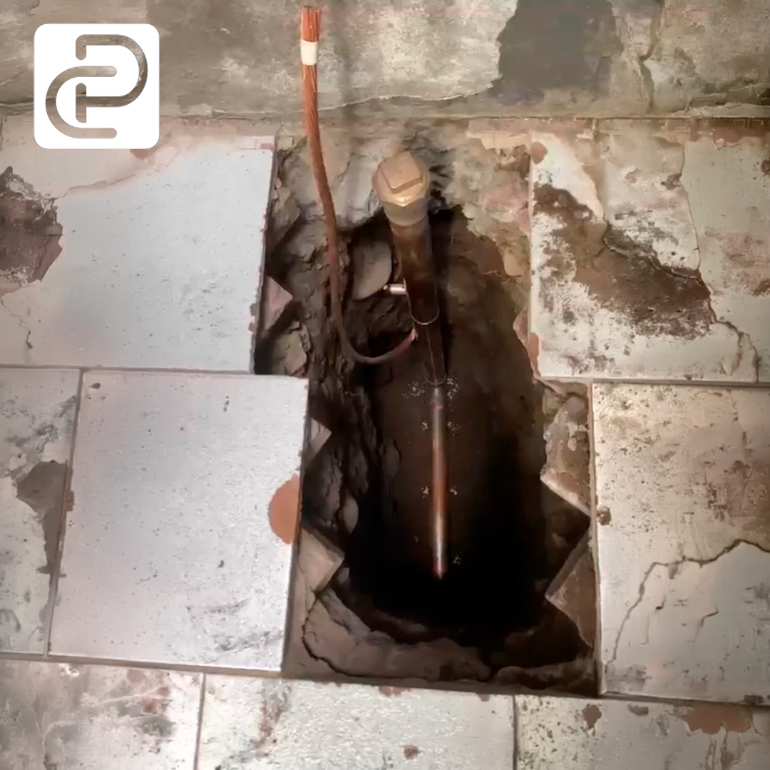 Electrodo de puesta a tierra instalado bajo el piso, con cable de cobre conectado — instalación real Corpar SpA